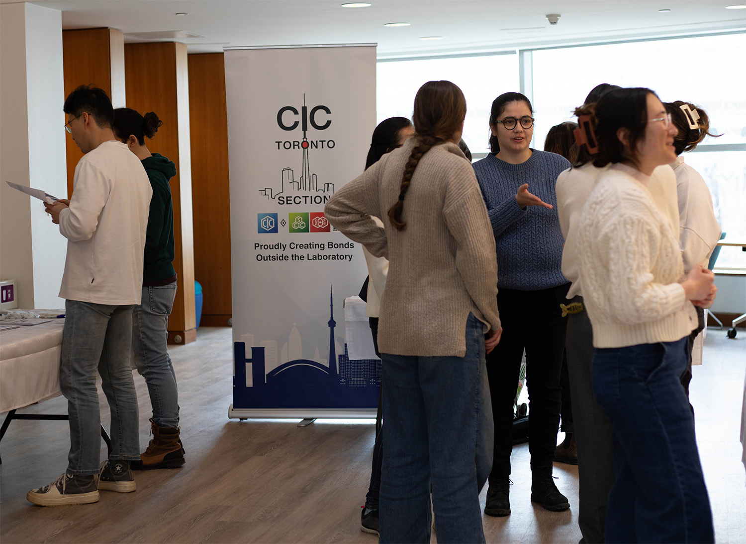 Students gather in front of a CIC Banner at a networking event.