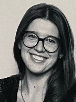 Head shot of Karolina Rabeda, a young white woman with glasses and shoulder-length dark hair.