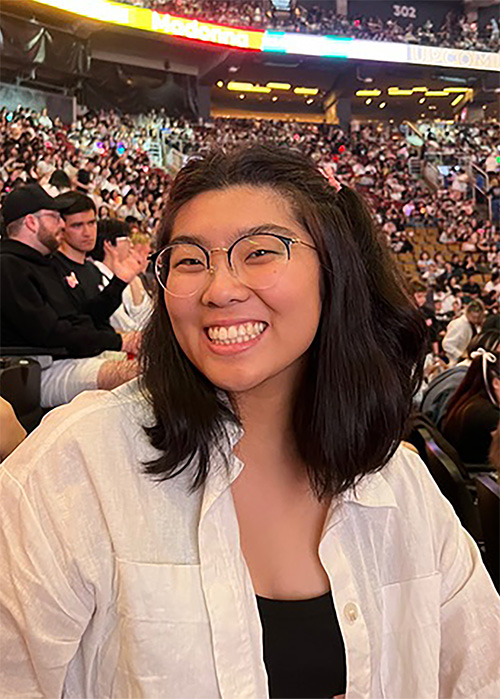 Portrait of Chemistry student Camille Tsang at a concert, smiling at the camera.