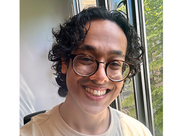 Close head shot of Chemistry student Eaarad Aftab, a brown man with curly hair and glasses