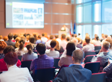 A lecture hall with big screen and audience