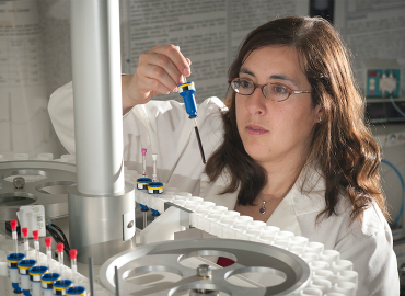 Professor Myrna Simpson works with equipment in a lab.